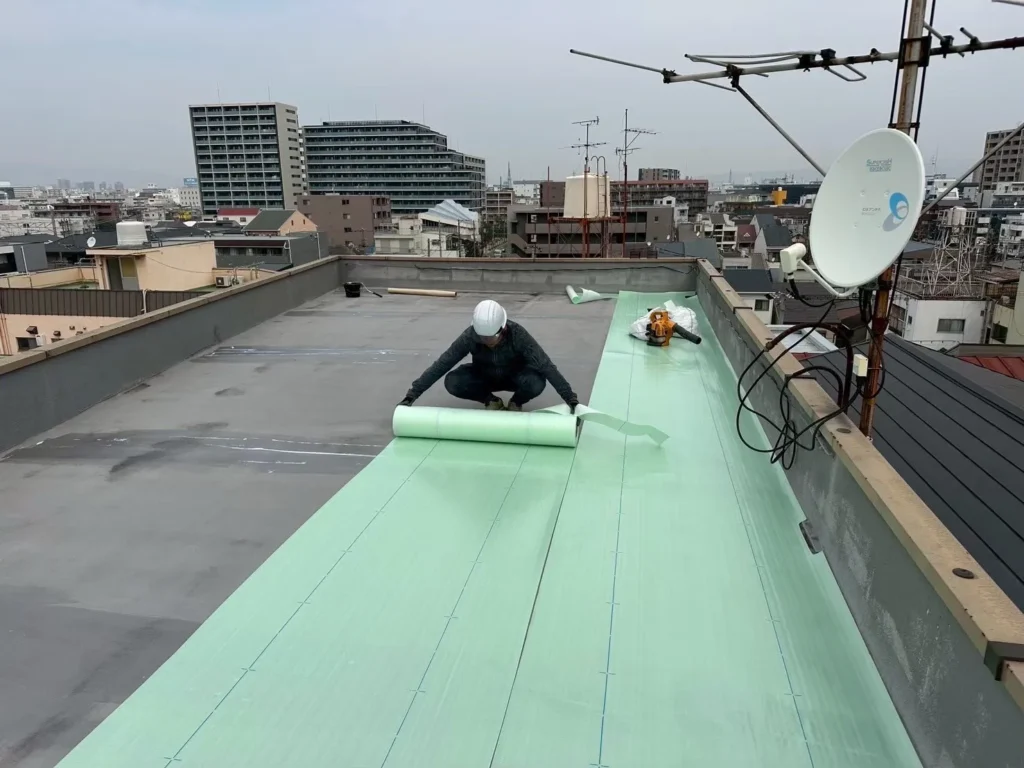 門真市の屋上防水工事：塩ビシート防水の絶縁シート敷設作業