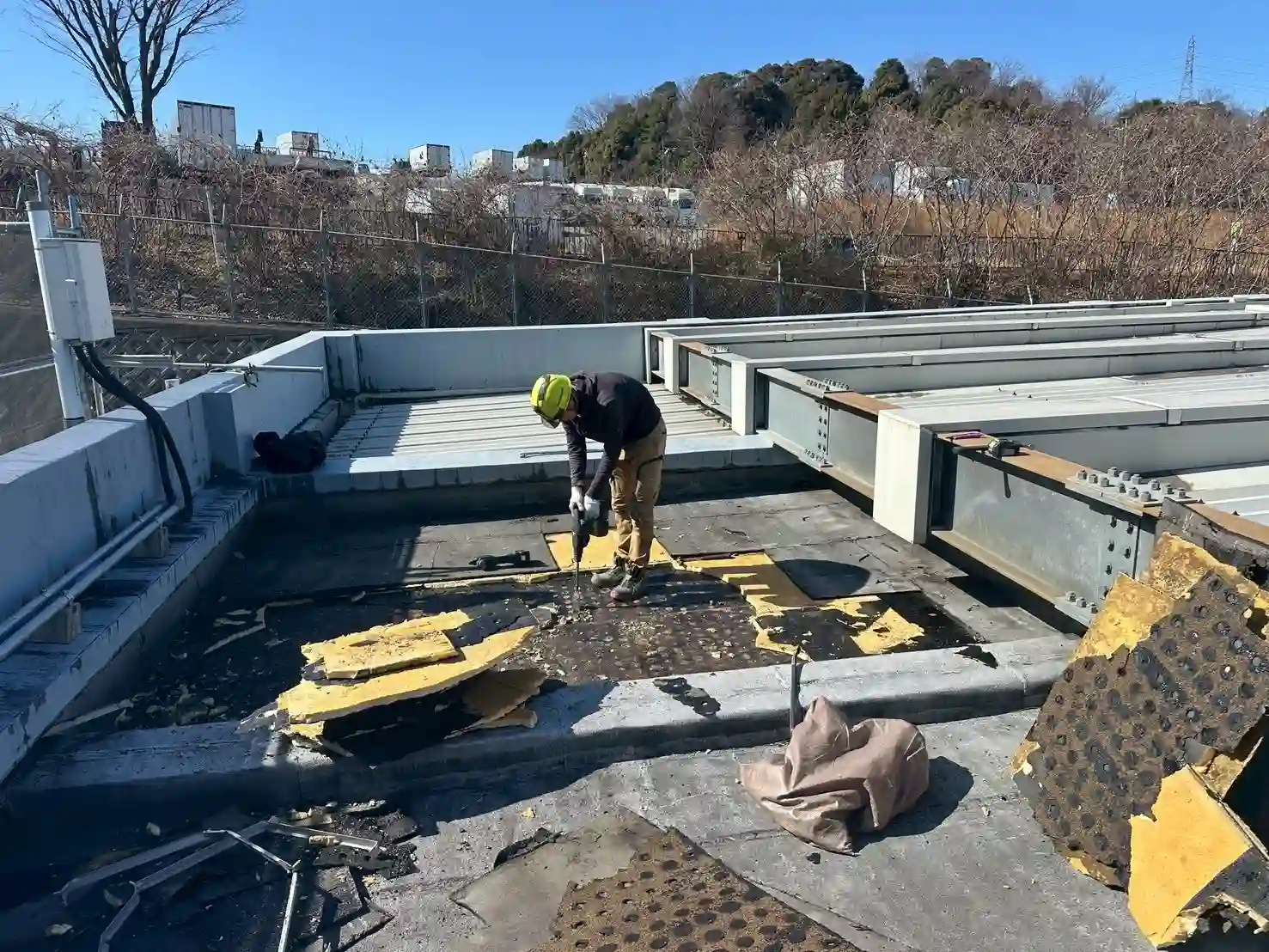 既存の防水層と古い断熱材をハンマードリルで全撤去する様子