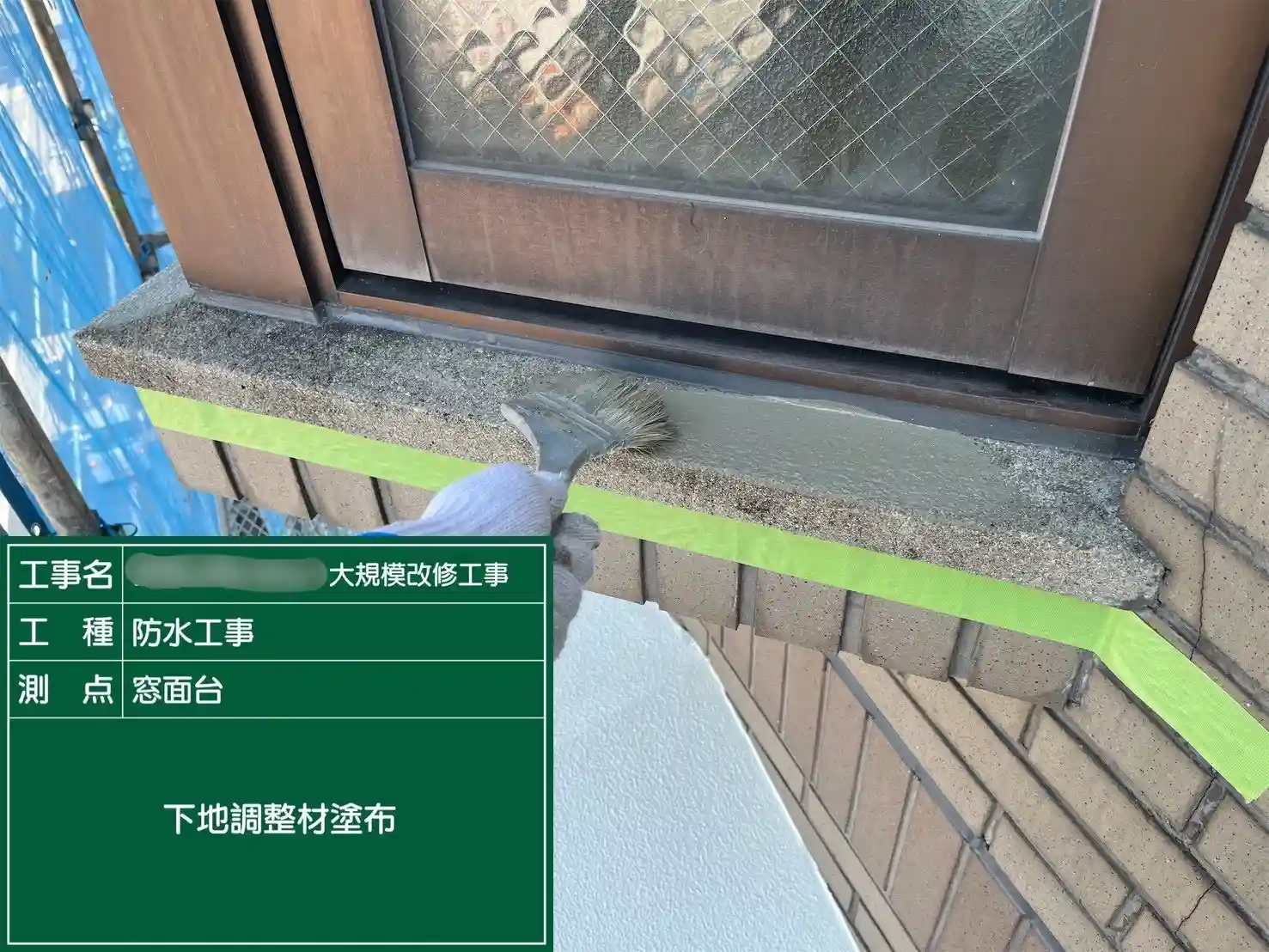 凹凸を平滑に整えるための下地調整材を塗布する様子